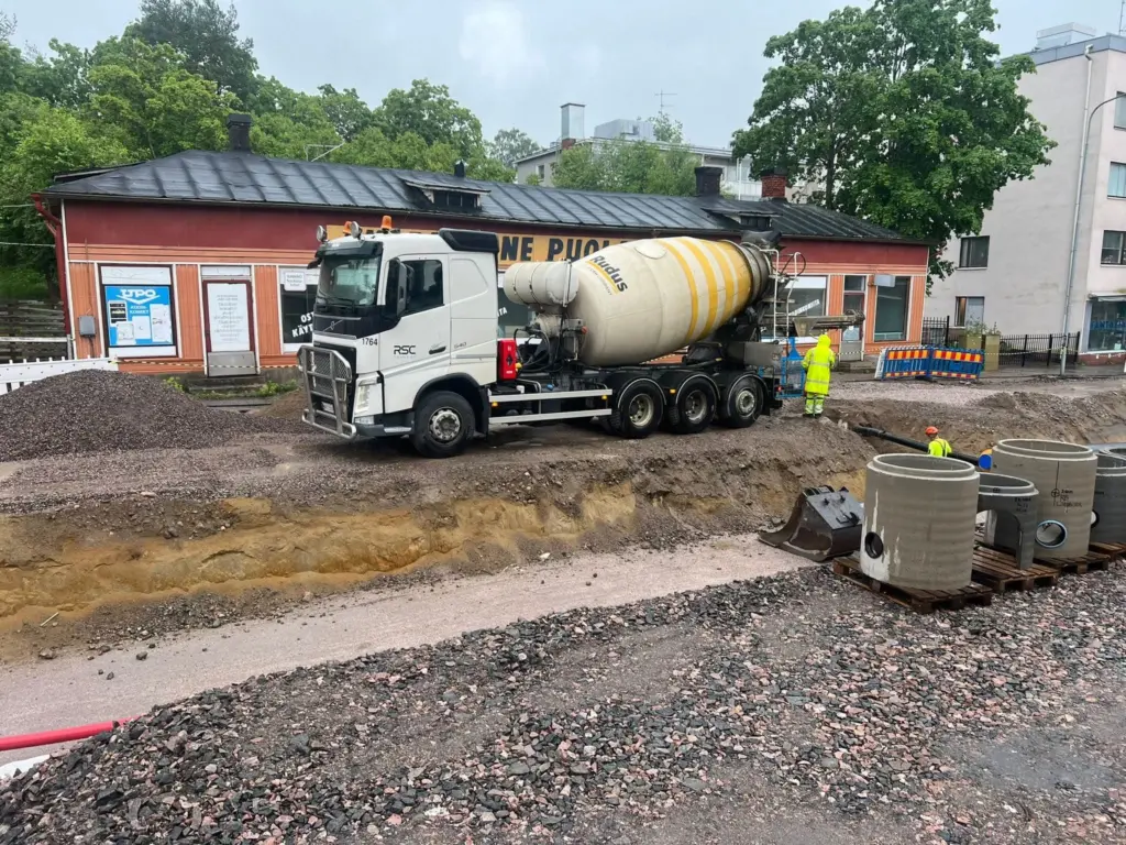 Betoniauto ja työntekijöitä rakennustyömaalla